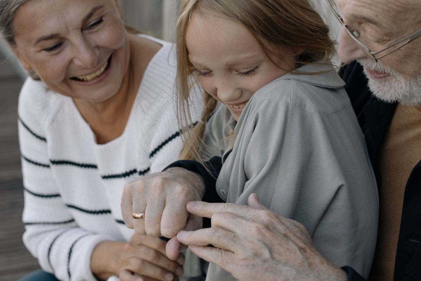 Grandparents laughing together with their granddaughter.